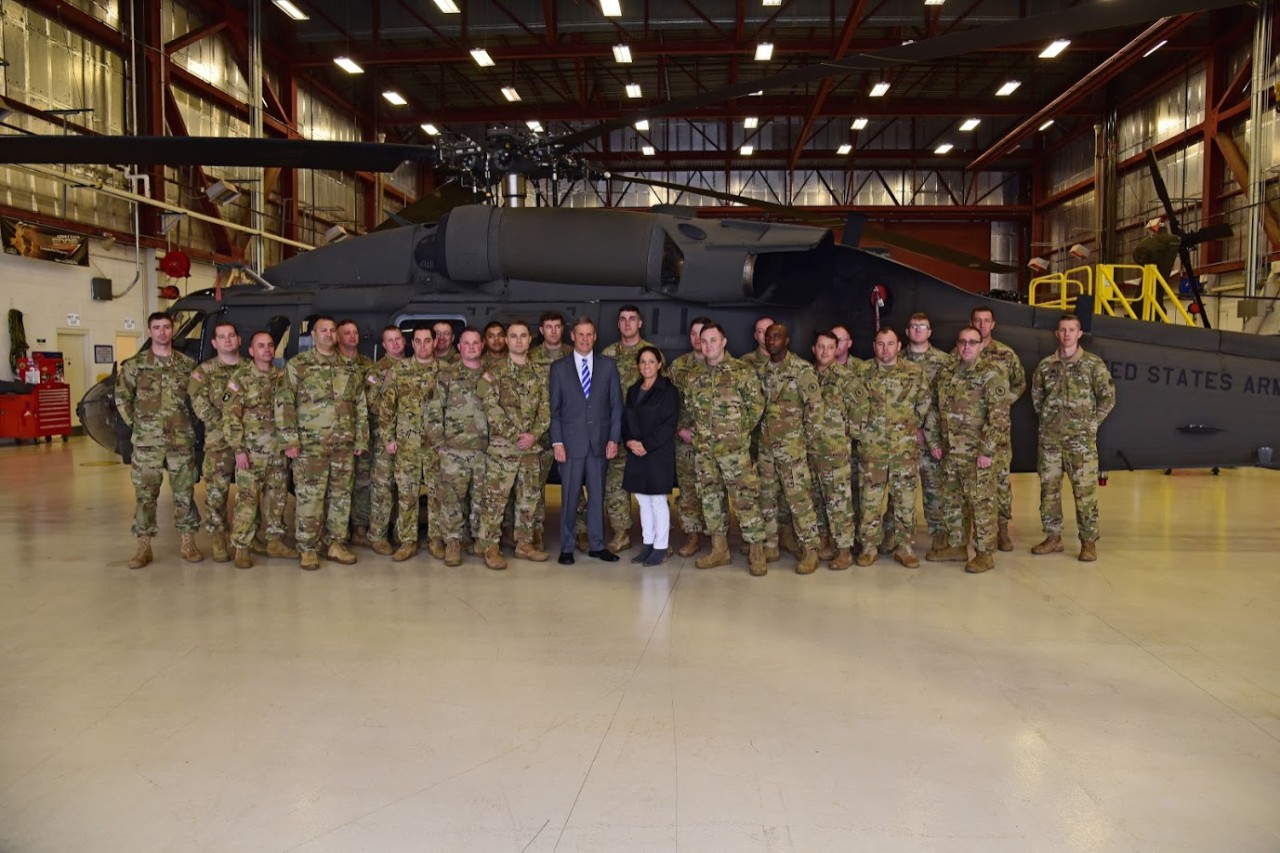 Tennessee Governor Bill Lee and First Lady Maria along with Tennessee National Guard troops in front of a helicopter